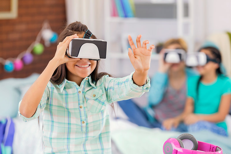 Girls using virtual reality goggles during a party