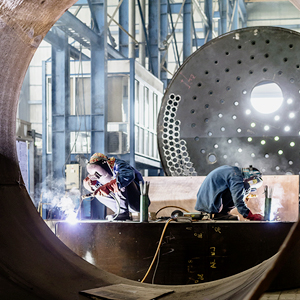 Two workers welding in a factory.