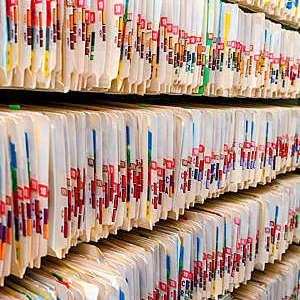 Labelled medical records stored in an open file cabinet.