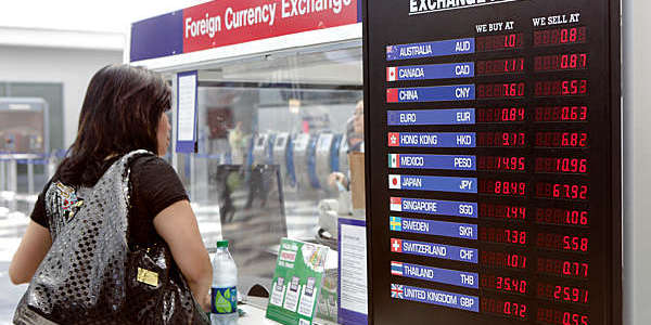 Woman exchanges money at a currency exchange kiosk at Chicago's O'Hare International Airport.