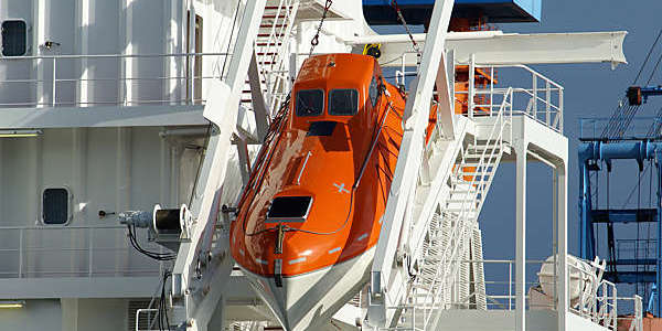 Free-fall lifeboat stowed in a sloping slipway on board a ship.