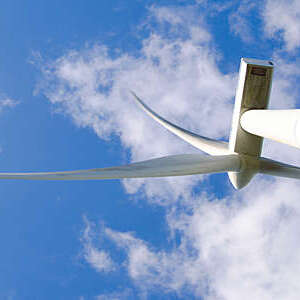 Wind turbines in mountain against sky.